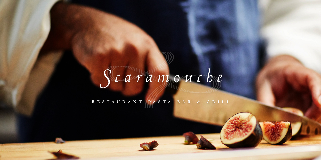 Chef cutting figs on a wooden cutting board with Scaramouche Logo overlayed on top of it